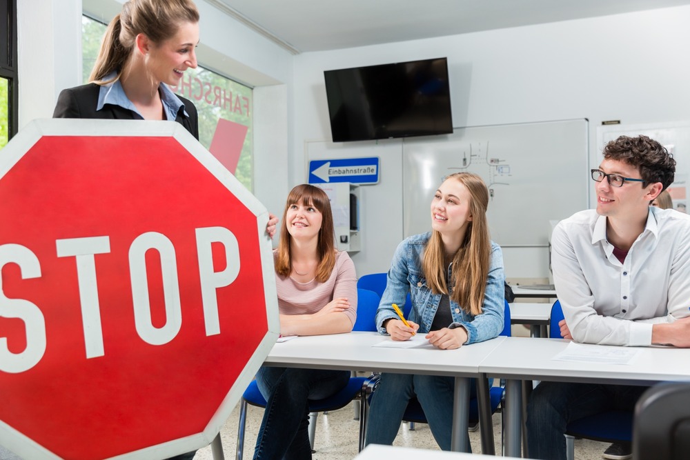 profesora de autoescuela con señal de stop